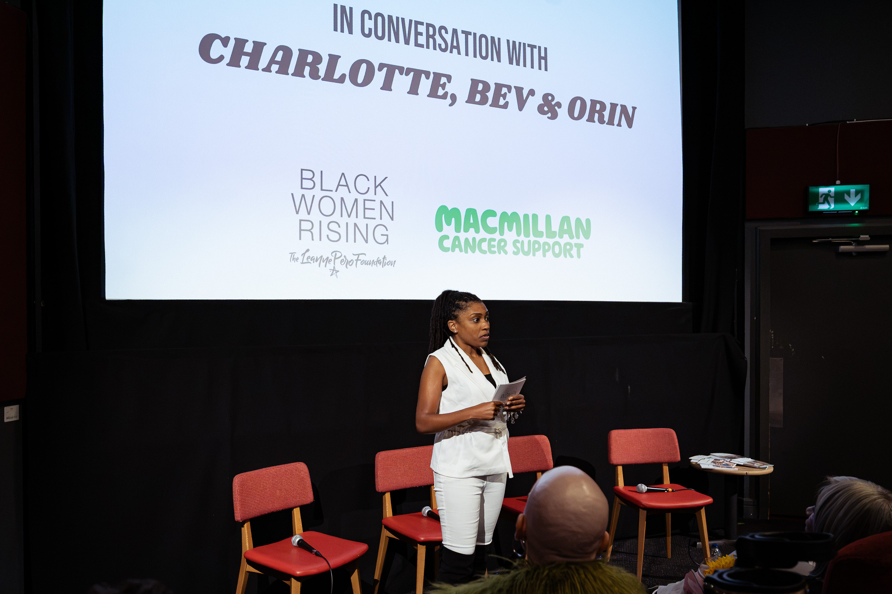 Charlotte standing in front of a group of people introducing her video screening.