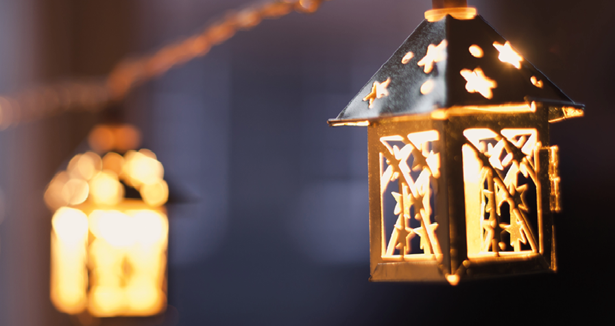 Christmas lanterns with candles inside, hanging from a string