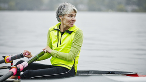 Woman with grey hair rowing on the river