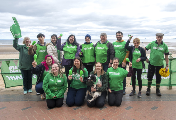 A group of Macmillan volunteers wearing T-shirts on the seafront
