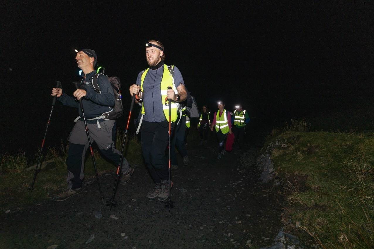 People hiking at night, some with walking poles