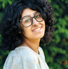 Image of a teenage girl. She is wearing glasses and smiling